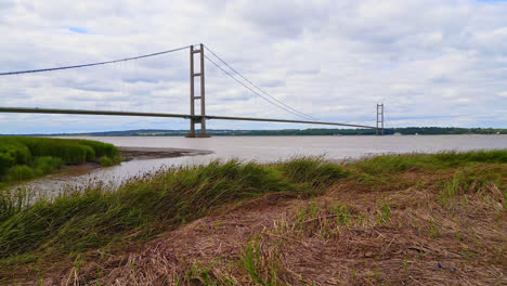 Aerial-drone-perspective-of-Humber-Bridge:-12th-largest-suspension-span-globally,-spanning-River-Humber,-connecting-Lincolnshire-to-Humberside-with-traffic