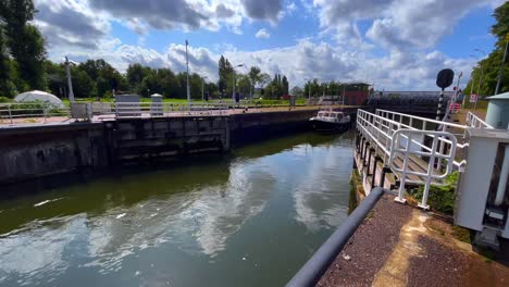 Sluice-doors-are-opening-while-a-little-ship-is-waiting-to-pass-by-in-Amsterdam