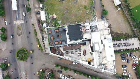 Blick-Von-Oben-Auf-Das-Terrassengartenrestaurant,-Luftaufnahme-Eines-Wolkenkratzergebäudes-In-Der-Stadt-Rajkot,-Nach-Unten-Schwenkende-Kamera-Und-Auf-Der-Straße-Vorbeifahrende-Fahrzeuge-Sind-Zu-Sehen