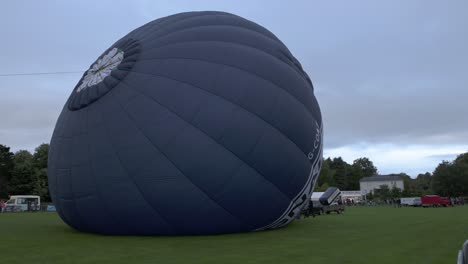 Hand-held-shot-of-a-hot-air-balloon-filling-up-with-air-at-Strathaven-Balloon-Festival