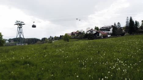 Flying-over-a-field-of-flowers-in-Italy's-rural-countryside-with-a-tram-coming-into-town-overhead