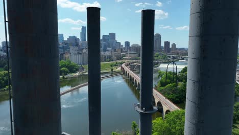 Reveal-of-Minneapolis,-MN-skyline-from-between-smokestacks-of-University-of-Minnesota-Southeast-Steamplant