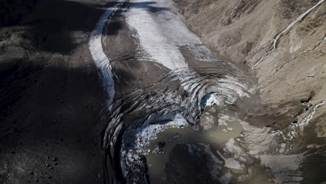 Debris-covered-Pasterze-glacier-at-the-foot-of-Grossglockner-Mountain,-Melting-glacier-due-to-global-warming,-Drone-shot