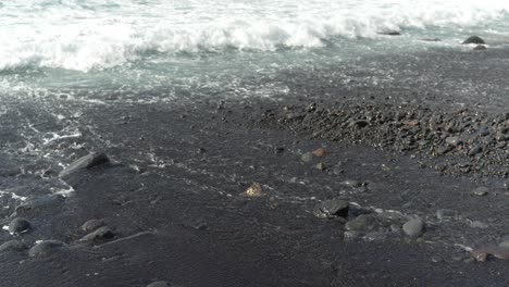 Ocean-waves-washing-off-black-beach-surface,-Los-Gigantes,-stable-shot