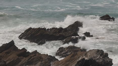 Slow-motion-shot-of-waves-crashing-against-rocks-off-the-Newquay-coastline