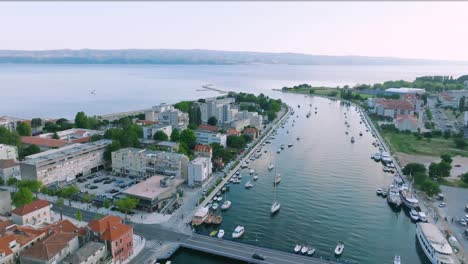 Drone-Shot-of-River-Cetina-bridge-in-the-town-of-Omis-surrounded-by-mountains-and-the-Adriatic-Sea,-Croatia