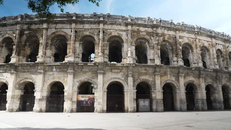 Von-Einem-Baum-Aus,-Blick-Auf-Die-Arenen-Von-Nîmes-Vom-Boden-Aus,-Mitten-Am-Tag-Bei-Gutem-Wetter