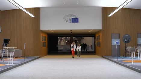 People-Walking-Through-Large-Hallway-With-Broadcasting-Equipment-Set-Up-In-The-European-Parliament-Building-In-Brussels