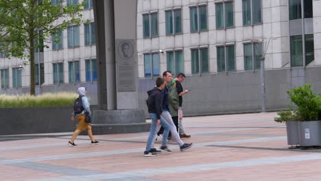 Lady-With-Walking-Stick-Walking-With-Partner-Across-Entrance-To-European-Parliament-Building-In-Brussels