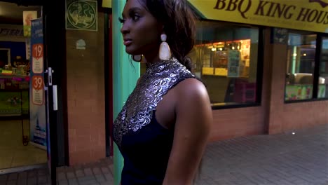 Una-Modelo-Afroamericana-Camina-Por-La-Plaza-De-Chinatown-En-Chicago-Con-Un-Hermoso-Y-Elegante-Vestido-Negro-Con-Un-Bolso-De-Mano-Rojo