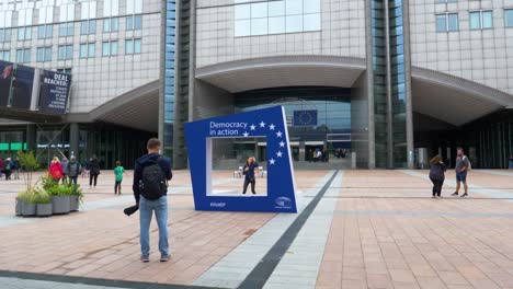 Family-Preparing-To-Take-Photo-Beside-Large-EU-Photo-Frame-Attraction-Outside-European-Parliament-Building-In-Brussels