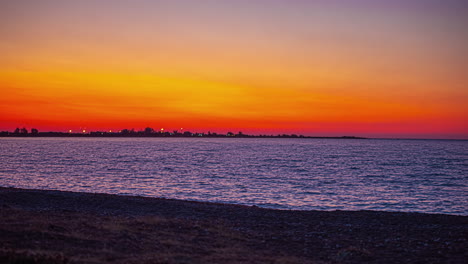 Orangefarbener-Sonnenaufgang-Im-Zeitraffer-Am-Meer-Mit-Strand-Im-Vordergrund,-Lettland