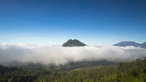 Volcán-Asomando-Por-Encima-De-Las-Nubes,-Java-Oriental,-Indonesia,-Lapso-De-Tiempo-Con-Cielo-Azul,-Espacio-De-Copia
