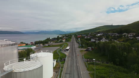 Flying-Above-Coastal-Road-Through-Industries-In-Tromso,-Norway