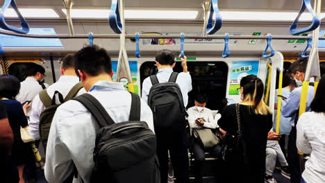Viajeros-Con-Exceso-De-Trabajo-En-Un-Metro-De-Hong-Kong-Abarrotado-Después-De-Largas-Horas-Extras