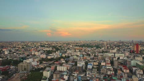 Dense-Urban-City-Life-from-Above-with-Orange-Glowing-Clouds-in-Bangkok,-Thailand