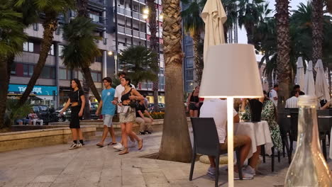 Gente-Caminando-Frente-Al-Restaurante-En-El-Callejón-De-Las-Palmeras-En-El-Parque-Corso-Vittorio-Emanuele-En-El-Centro-De-La-Ciudad-De-Bari-Puglia-Italia