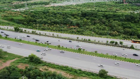 Aerial-view-from-above-of-cars,-busses,-and-trucks-traveling-in-congested-road-traffic-on-the-highway-in-Pakistan