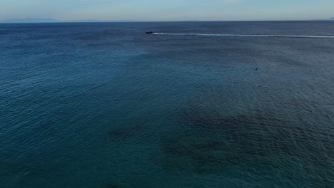 Riesige-Meeresoberfläche-Und-Motorbootsegeln-Am-Tiefblauen-Meereshorizont,-An-Einer-Wunderschönen-Bucht-Mit-Stränden-Und-Touristendörfern-In-Albanien,-Sommerferienkonzept