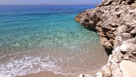 Colorful-sea-scenery-with-blue-turquoise-water-and-white-waves-washing-the-cliffs-on-beach-on-summer-vacation-in-Mediterranean-shoreline