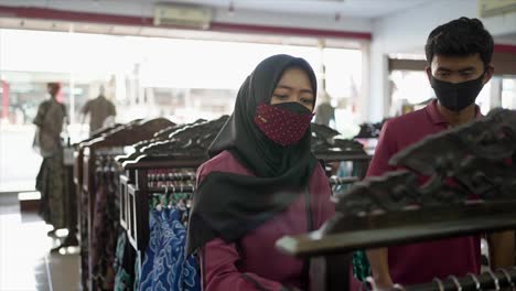 Happy-couple-choosing-new-clothes-at-the-clothing-shop