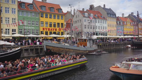 Ein-Friedlicher-Blick-über-Den-Nyhavn,-Während-Ein-Boot-Voller-Touristen-Durch-Den-Kanal-Manövriert