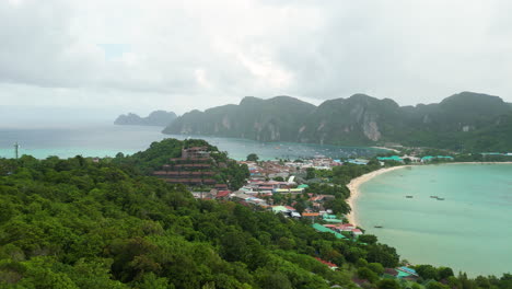 Aerial-forward-flight-showing-Koh-Phi-Phi-Island-with-sandy-beach,-resort-and-clear-water-during-foggy-day