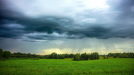 Rain-clouds-slide-over-a-green-landscape-with-trees-and-meadows