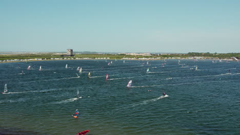 Multiple-Windsurfing-People-On-Blue-Water-In-Brouwersdam-Beach,-Netherlands---aerial-shot