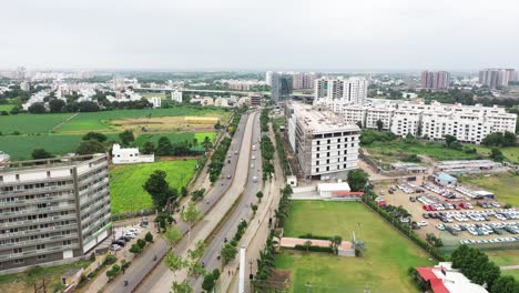Aerial-view-of-150-feet-ring-road-of-Rajkot-City,-thousands-of-four-wheelers-are-seen-parked-in-the-parking-lot