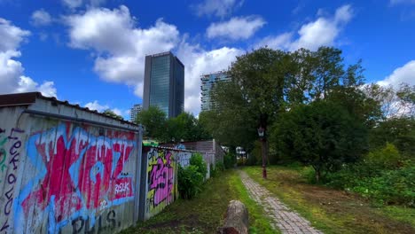 Industrial-barns-with-graffiti-in-contrast-with-modern-architecture-flat-buildings