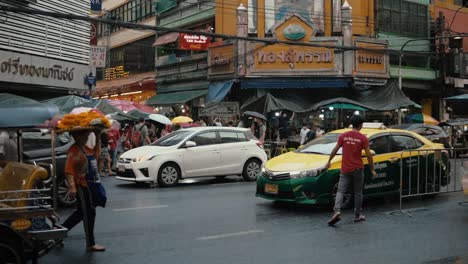 People-walking-through-Chinatown-in-Bangkok,-Thailand-at-a-rainy-day
