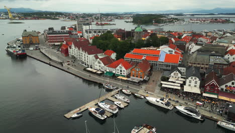 Aerial-arc-over-Stavanger-harbor-with-its-historic-wooden-cottages,-Norway