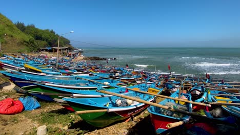 The-many-colorful-fishing-boats-on-the-coastline-of-Menganti-beach-in-Java,-Indonesia