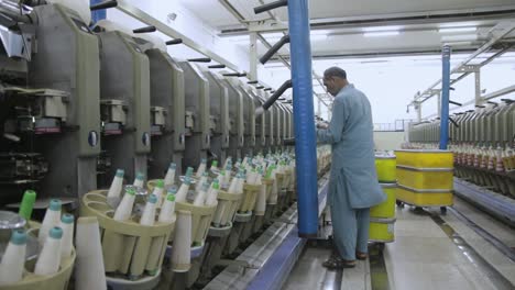 Workers-Maintaining-Textile-Spools,-Manufacturing-Thread-Process