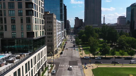 Drone-shot-following-traffic-on-the-streets-of-sunny,-downtown-Indianapolis,-USA