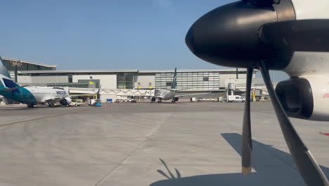 Airplane-Driving-Past-Parked-WestJet-Airplanes-at-Airport-Gates-at-Calgary-YYC-Airport-on-7-18-2023