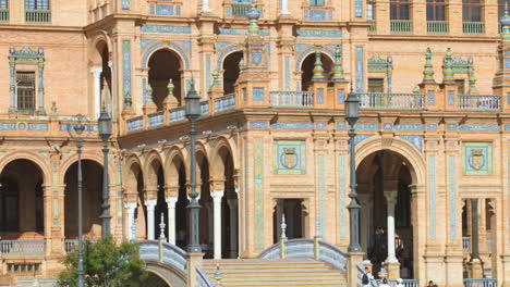 Die-Spanische-Flagge-Weht-Auf-Dem-Hauptgebäude-Der-Plaza-De-España-In-Sevilla-Und-Neigt-Sich-Nach-Unten,-Um-Blick-Auf-Die-Straße-Zu-Werfen