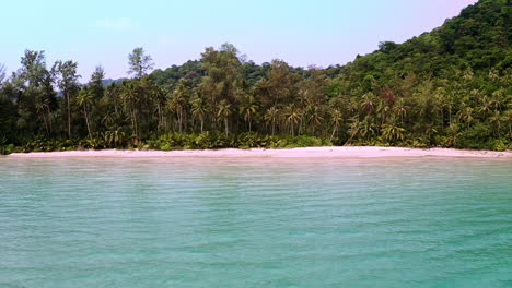 Tropical-palm-jungle-on-Koh-Kood-beach-in-azure-sea-lagoon,-Thailand
