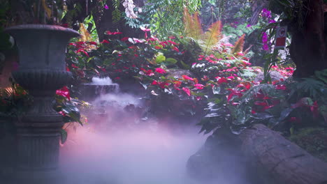 Enchanting-garden-with-blooming-flowers-and-bubbling-fountain-in-mist