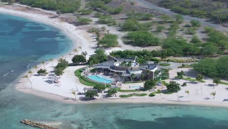Aerial-orbiting-shot-of-luxury-hotel-resort-with-pool-and-golden-beach-in-front-of-Caribbean-sea---paradise-on-Dominican-republic