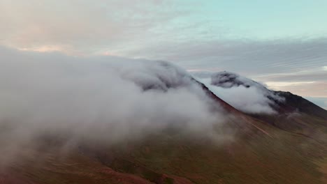 Nubes-Rodando-Hacia-Las-Montañas-De-Borgarfjordur-Eystri,-Islandia---Drone-Aéreo