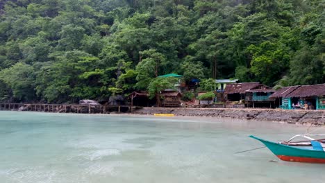 Scenic-view-of-jetty-and-tourist-shops-in-calm-lagoon-with-crystal-clear-turquoise-water-on-island-hopping-tour-in-Palawan,-Philippines,-Southeast-Asia