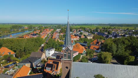 Circle-pan-to-right-on-church-bell-tower-of-cute-Dutch-village-Ilpendam-in-the-Netherlands