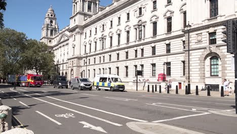 A-London-Fire-Brigade-emergency-foam-unit-fire-truck-with-its-blue-lights-flashing-drives-past-the-UK-Treasury-building-on-Parliament-Square