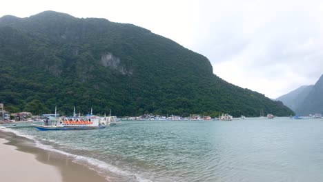 Playa-De-Arena-Blanca-Bordeada-De-Cafés,-Restaurantes-Y-Bares-Con-Una-Vista-Panorámica-De-Las-Islas-Tropicales-Y-El-Océano-En-El-Nido,-Palawan,-Filipinas