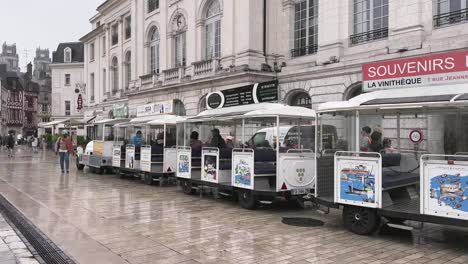 Tourist-train-waiting-to-start-tour-around-Orleans,-France-on-main-square-Jeanne-d'Arc