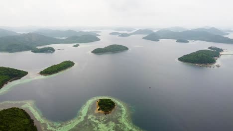 Vista-Aérea-Por-Drones-Del-Paisaje-De-Islas-Tropicales-Dispersas,-Arrecifes-De-Coral-Y-Océano-En-La-Bahía-De-Coron,-Palawan,-Filipinas