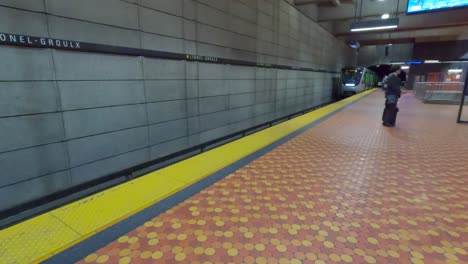 Pan-Left-Shot-as-a-Montreal-Metro-Train-Arrives-at-Lionel-Groulx-Station-in-Montreal,-Quebec