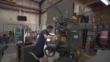 man-spinning-wheel-to-precise-location-on-industrial-machine
